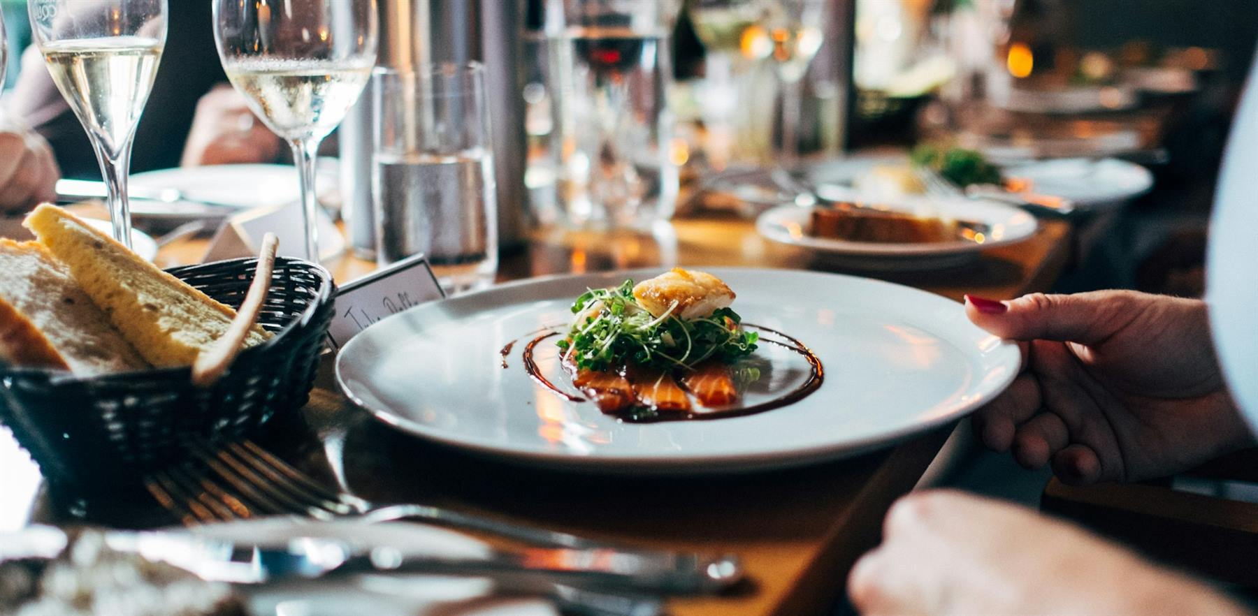 A plated dish on a restaurant table, with glassware in the background.